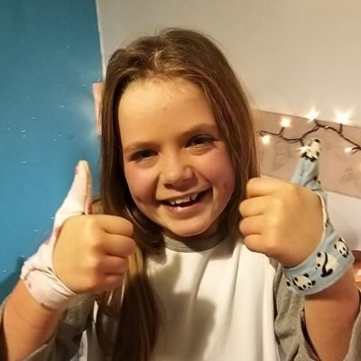 Girl aged 9 wearing thumb sucking glove on both hands