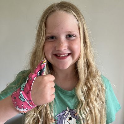 young girl wearing a Superhero thumb guard
