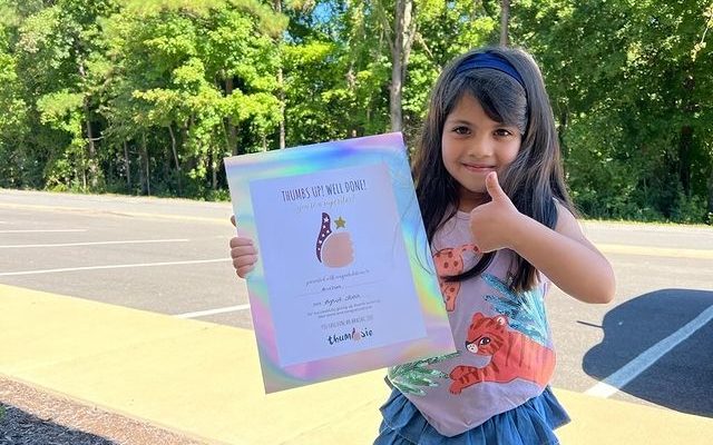 girl with her thumb sucking success certificate