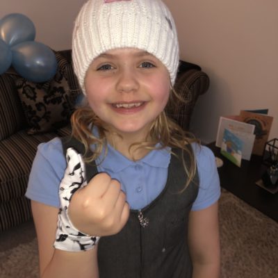 Girl wearing penguin Thumbsie thumb guard
