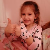 Girl aged 5 wearing Pink Panda thumb sucking gloves