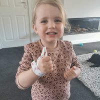 Little girl wearing Thumbsie thumb guards