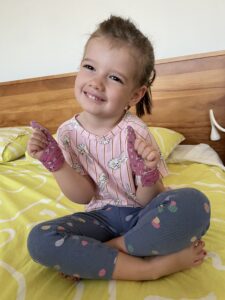 Toddler wearing a pink bunny top and blue leggings with matching Ballerina thumb guards.