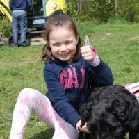 Little girl wearing her thumb guard with her dog