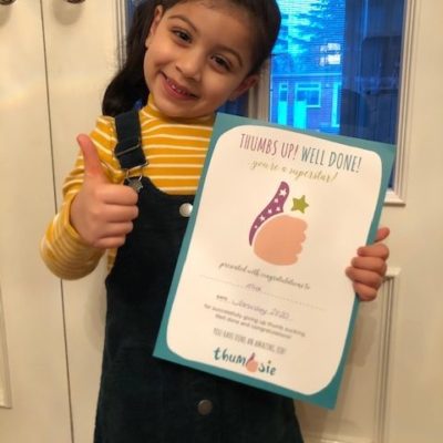 Girl proudly showing off her thumb sucking certificate