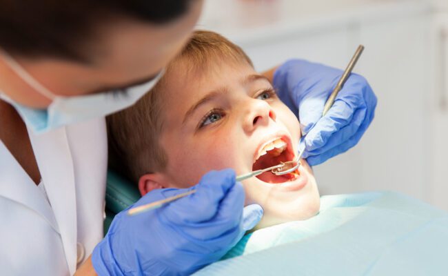 dentist examining boys teeth close up
