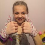  10 year old girl wearing matching flower thumb sucking gloves