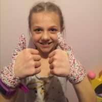 10 year old girl wearing matching flower thumb sucking gloves