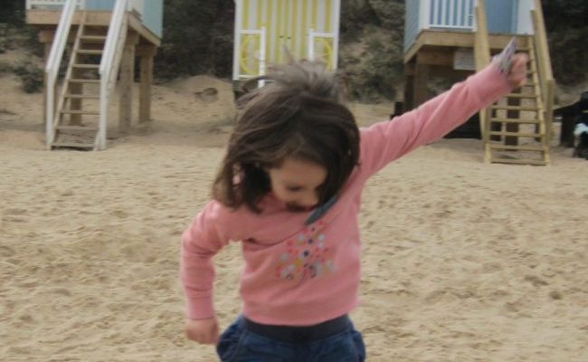little girl jumping for joy as no more thumb sucking